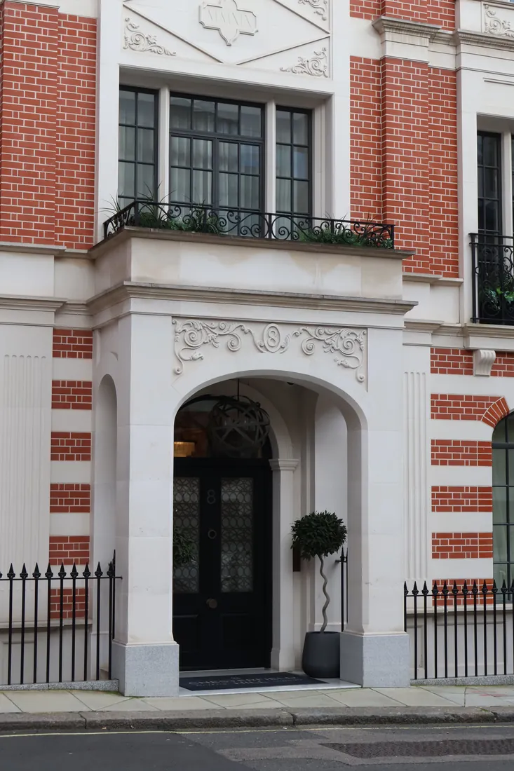 Red brick period townhouse with a stone archway entrance, Mayfair, London