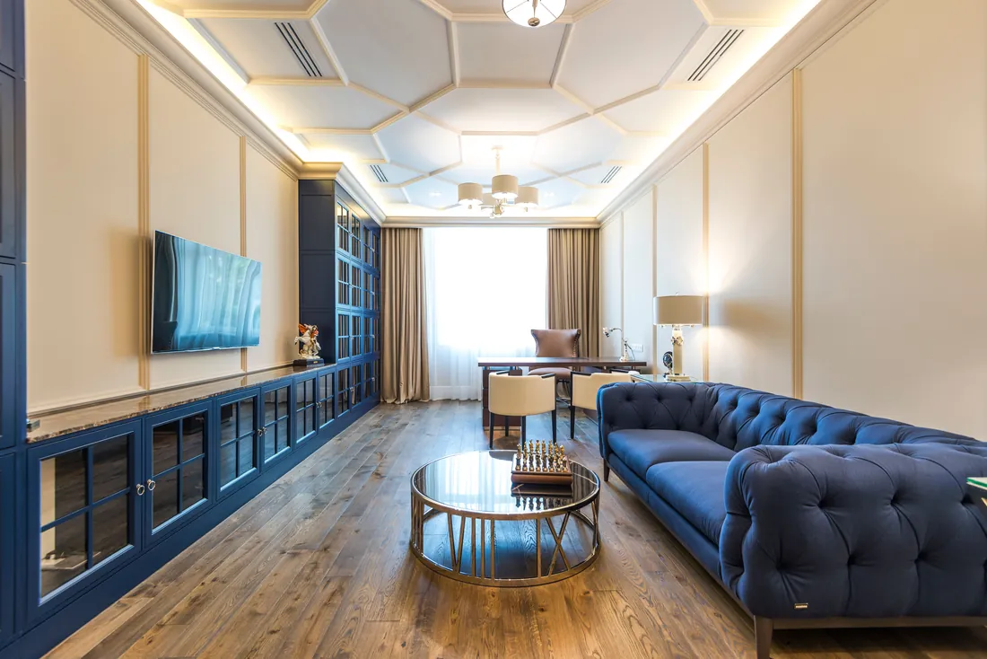Living room with a blue sofa against a painted feature wall, London