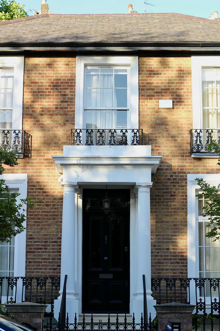 Brick period townhouse façade with sash windows, London