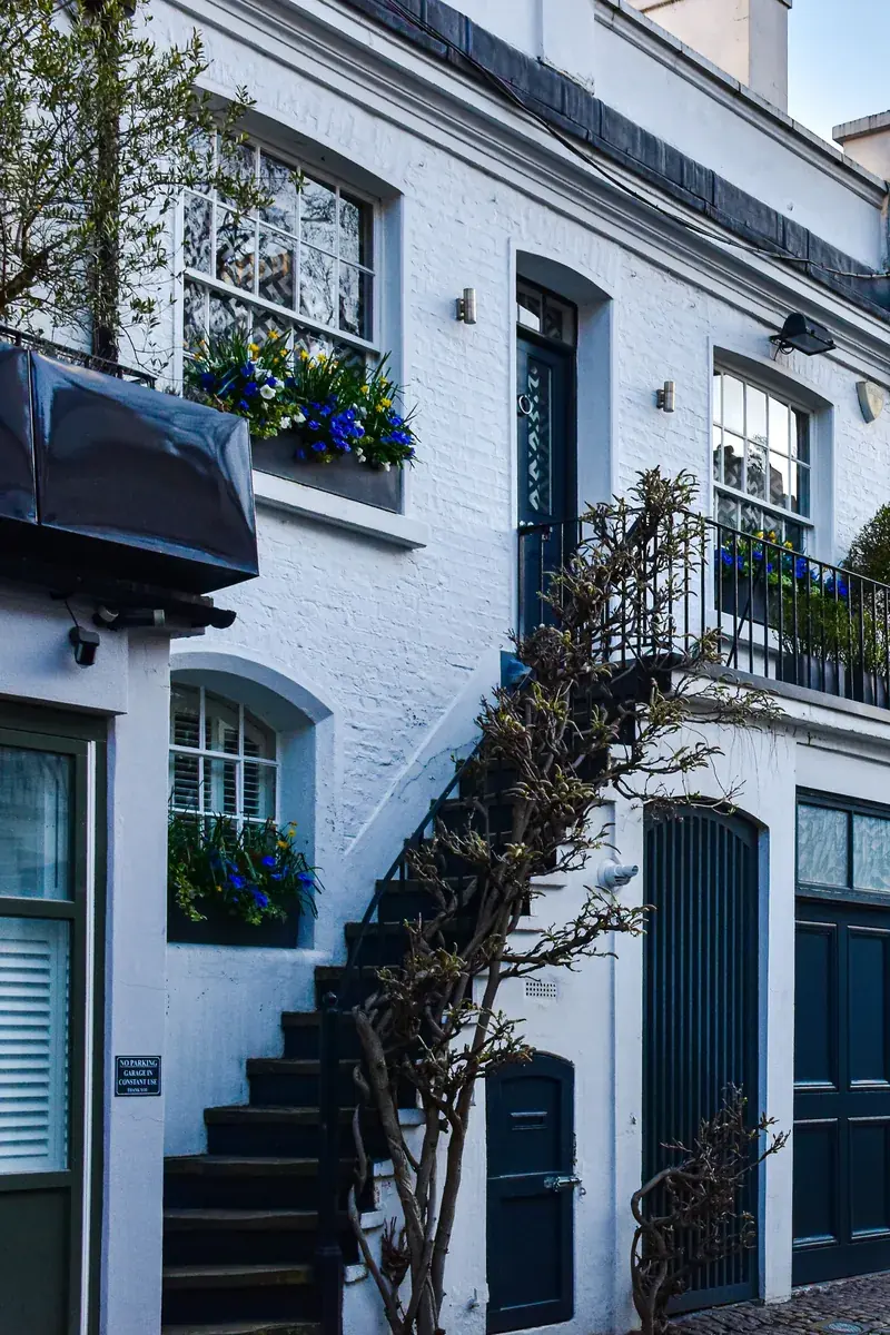 London mews with freshly painted white brickwork and blue doors by The Finishing House