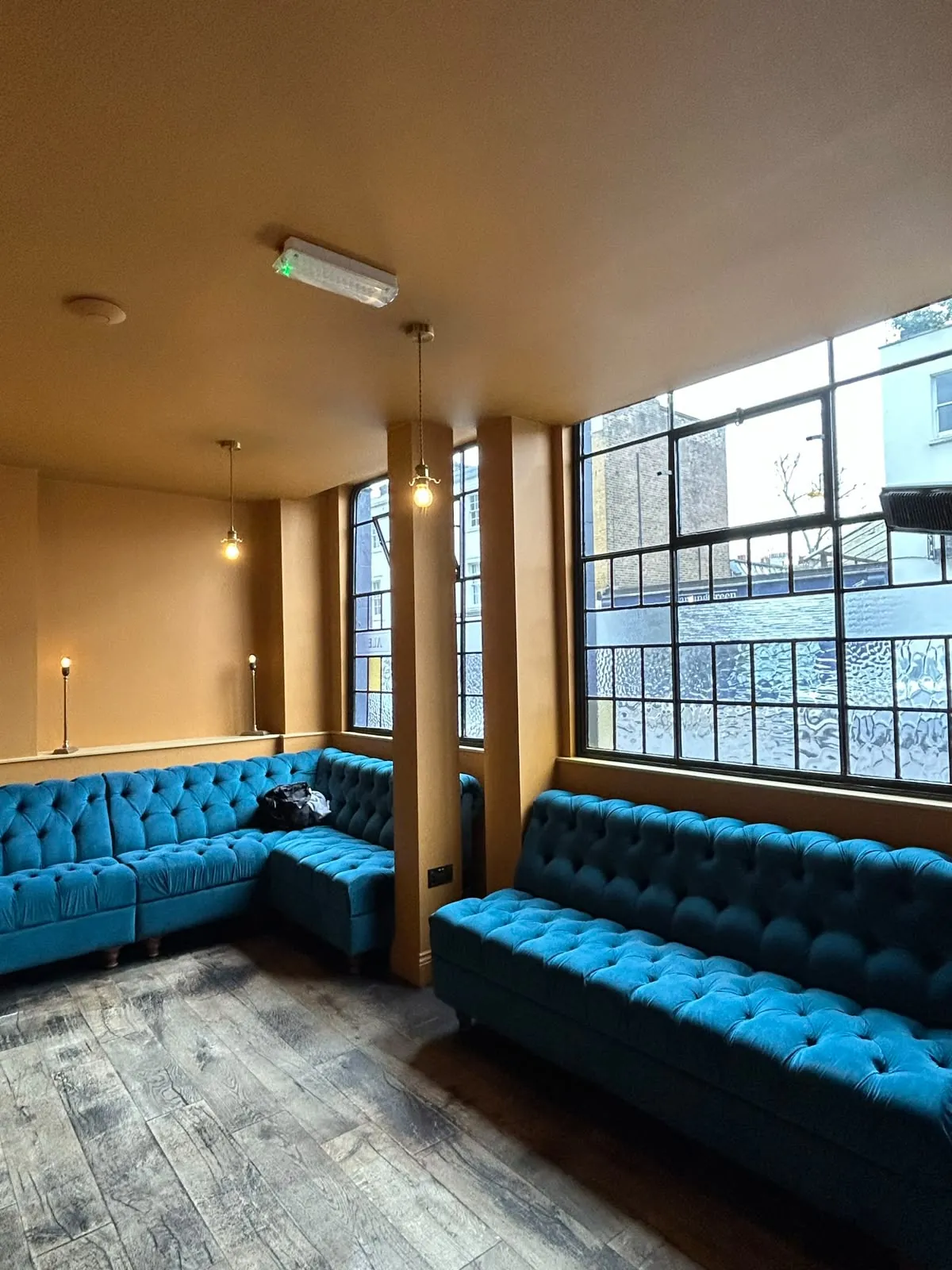 Bar walls in ochre above blue velvet banquettes, Notting Hill