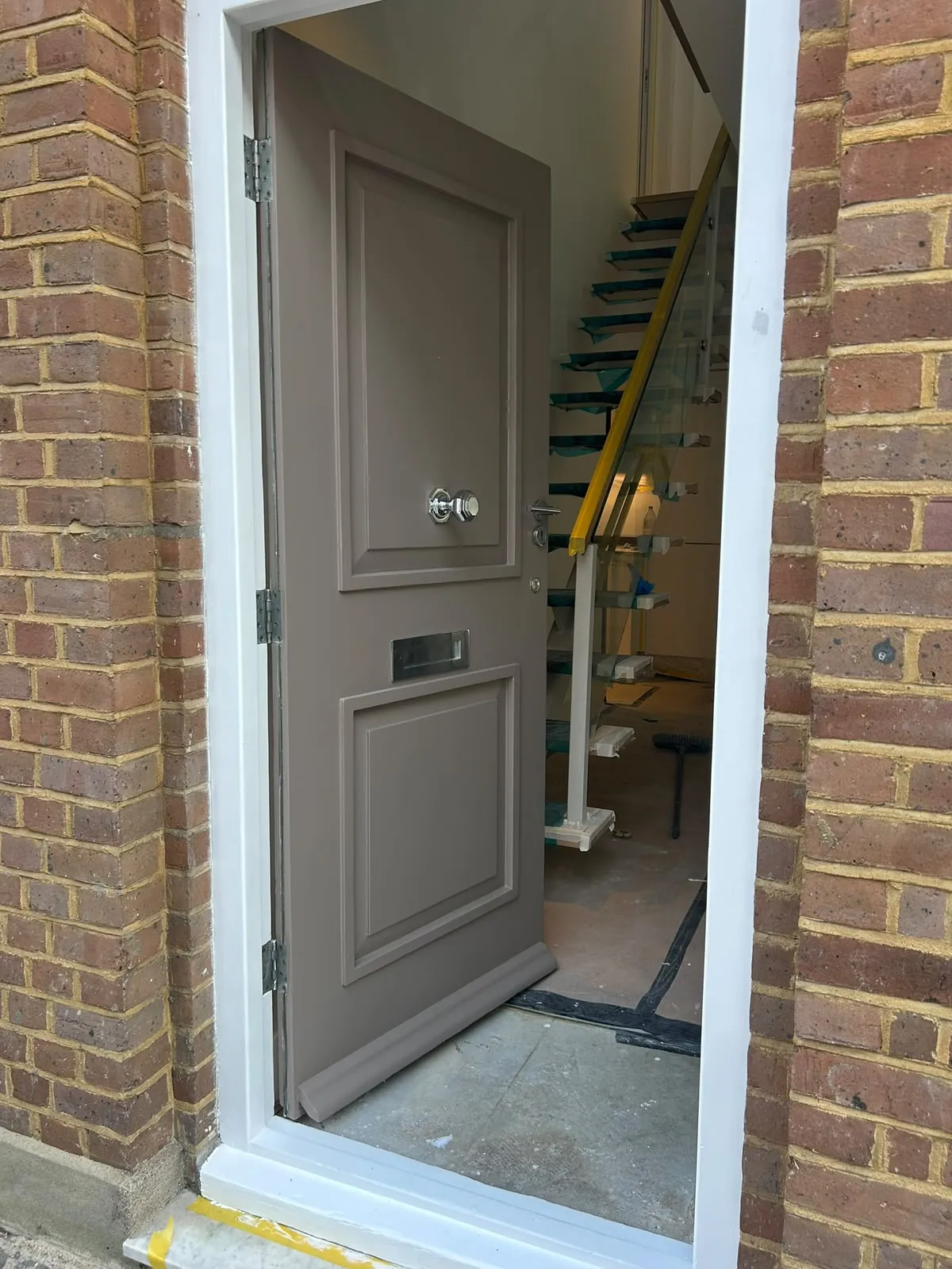 Exterior door in grey within a brick porch, Chelsea
