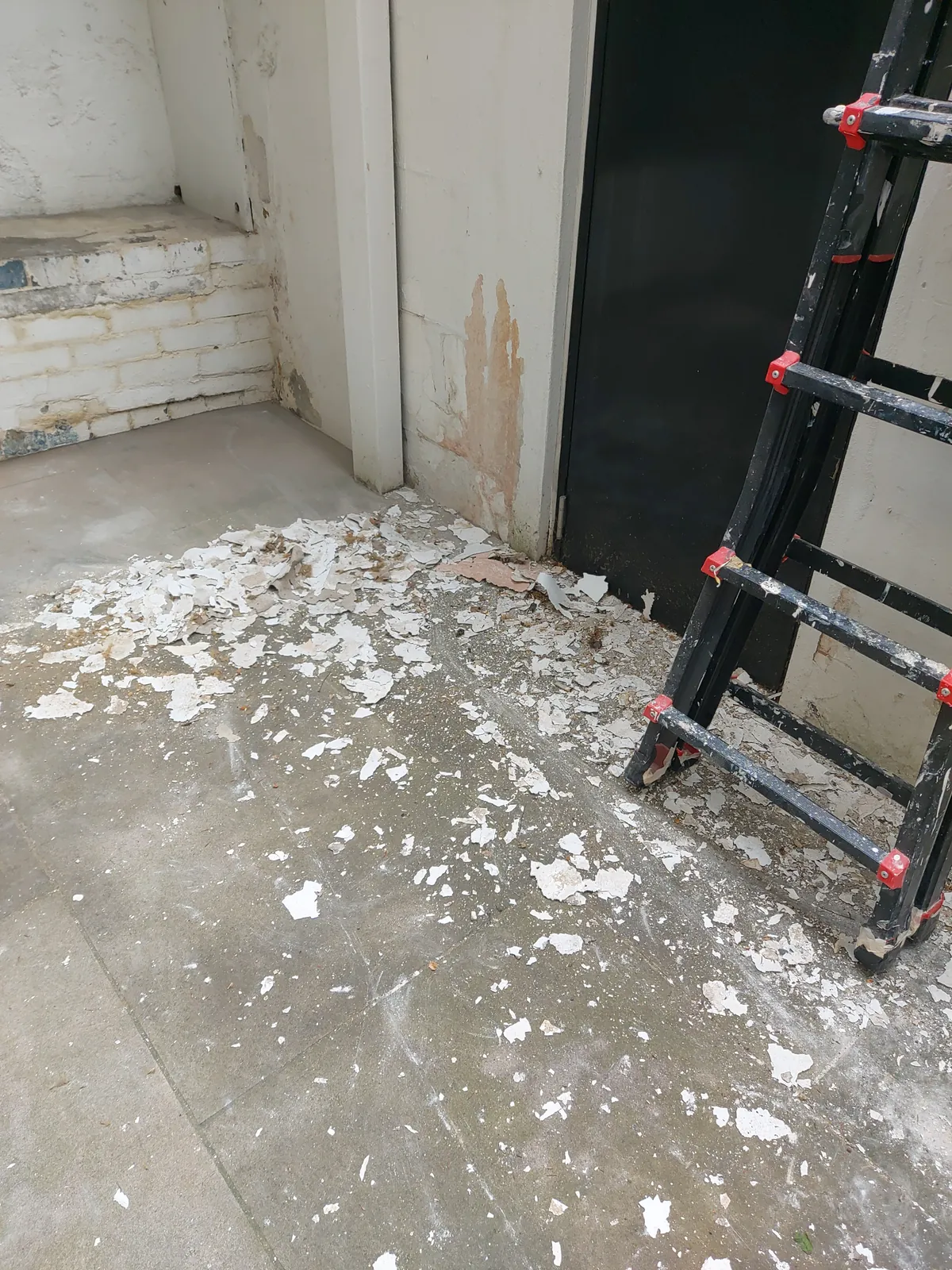 Flaking paint scraped back in a lightwell, Marylebone