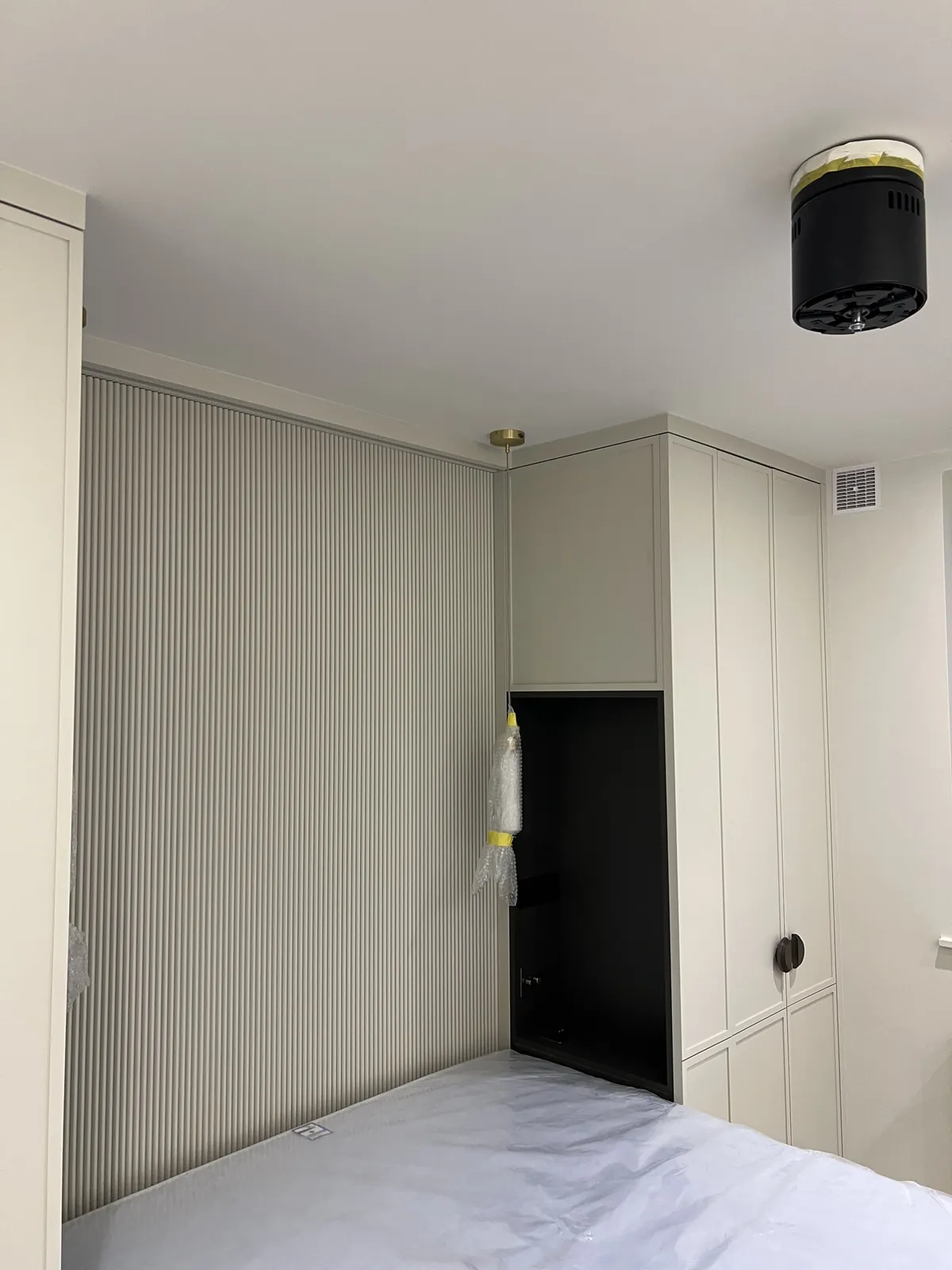Bedroom with fluted feature wall and wardrobes, St John’s Wood