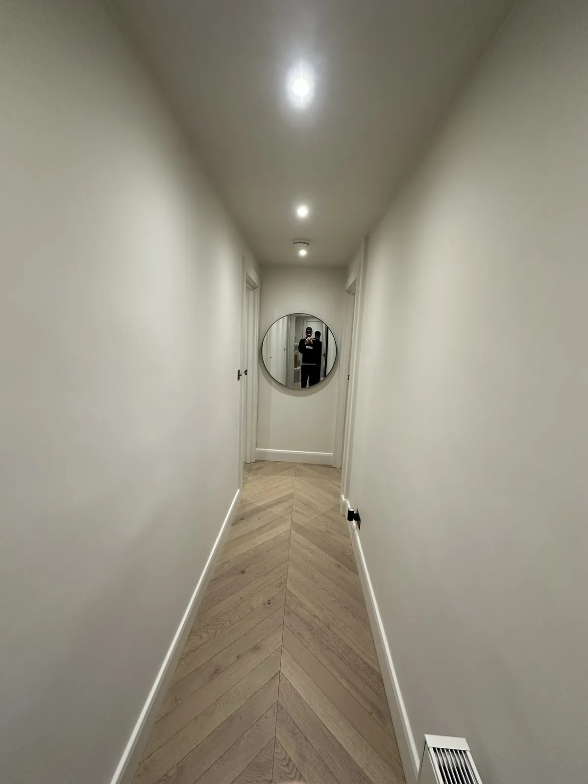 Hallway painted, herringbone floor and round mirror, St John’s Wood