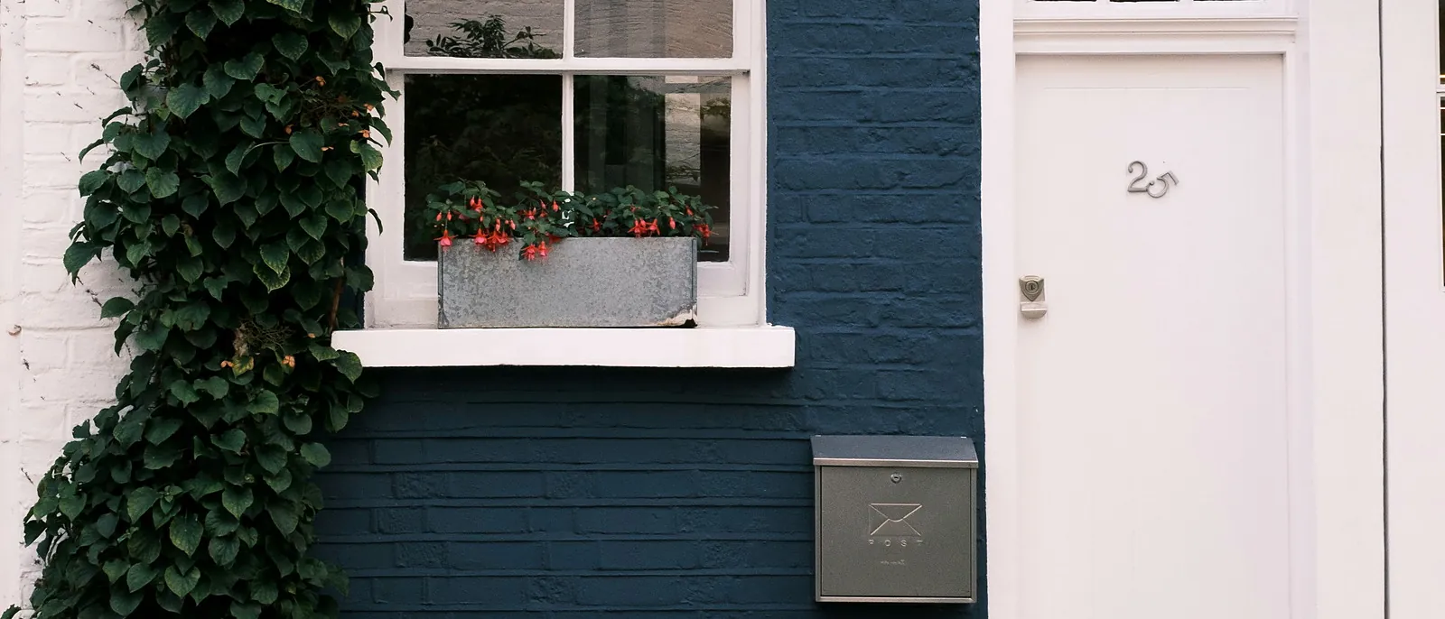 Hand-painted navy stucco façade and front door on a London townhouse by The Finishing House